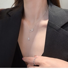 Dettaglio della collana a graffetta in argento e anello intrecciato con zirconi
