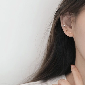 Minimalist gold hollow heart drop earrings on female model with a sleek modern design