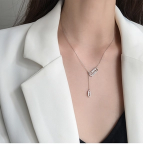 Macro di una collana a graffetta in argento con pendente in zirconi brillanti su un modello