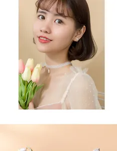 Detailed view of white lace choker with pearl pendant and golden base pearl earrings