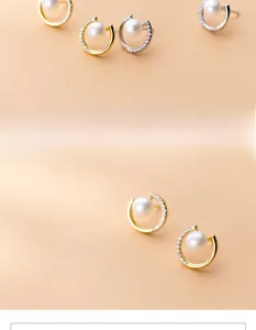 Detail of C-shaped pearl earrings with pave zircons in gold and silver plating