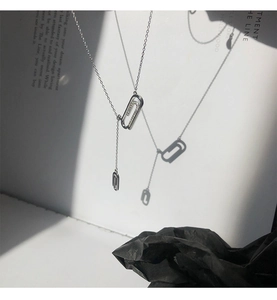 Dettaglio della collana a Y in argento a forma di graffetta con cristalli su carta artistica