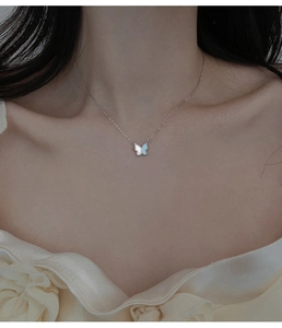 Gros plan du collier papillon minimaliste avec incrustation de nacre bleue et blanche