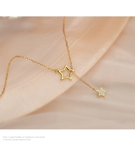 Détail macro du collier lasso étoile dorée avec pendentif pavé sur fond de soie élégant