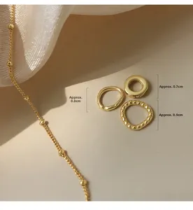 Detailed view of 0.8cm gold textured rings and chain with golden bean accents