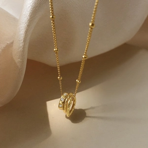Gold interlocking circle necklace with cubic zirconia and beads on a fine chain