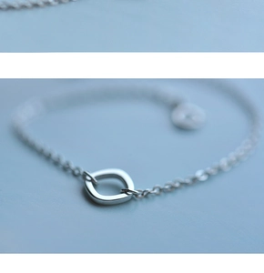 Macro detail of minimalist S925 sterling silver square pendant on delicate O-chain