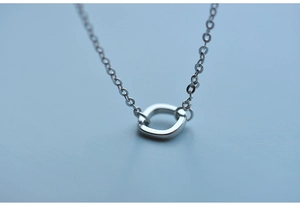 Close-up of minimalist silver pendant with rounded rectangle design on fine link chain