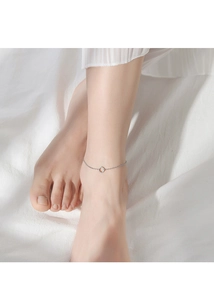 Minimalist silver geometric anklet featuring a small circular pendant on an ankle