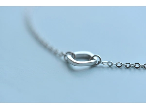 Macro view of minimalist sterling silver bracelet with irregular geometric square link