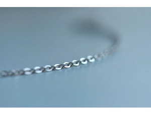 Macro shot of minimalist silver cable chain jewelry with polished oval links detail
