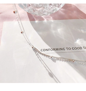Detailed view of silver double-layered snake and bead chain bracelet with soft light shadows