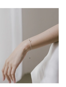Minimalist silver chain bracelet featuring a polished round geometric charm on wrist