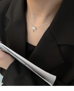 Close-up of cloud-shaped mother of pearl necklace with lightning bolt on silver chain