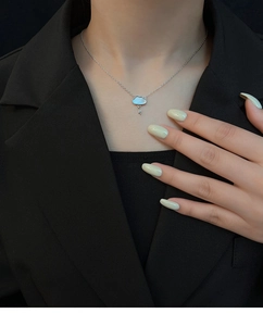 Detail of silver cloud and lightning pendant necklace worn on neck with professional styling
