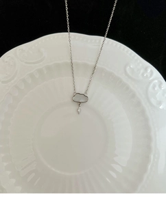 Close-up of cloud and lightning pendant with white mother-of-pearl inlay on metal chain