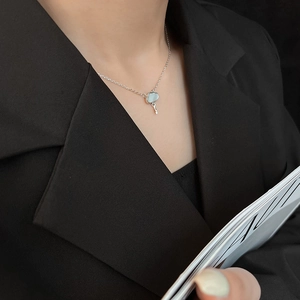 Minimalist silver cloud necklace with shell pendant worn on a black suit for women