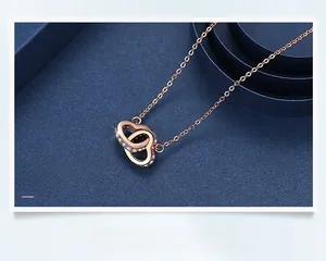 Detail of rose gold interlocking double heart pendant with cubic zirconia stones