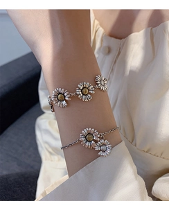 Detail of vintage S925 sterling silver daisy bracelets layered on a model wrist