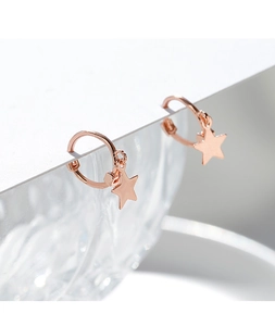 Macro shot of rose gold star pendant earring on display with crystalline glass background