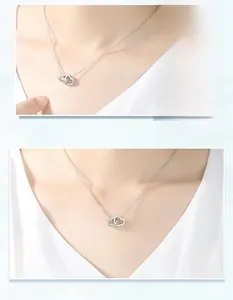 Detail of silver interlocking double heart necklace with zircon inlay on dainty O-chain