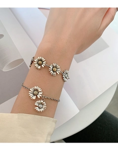 Detail of vintage s925 silver daisy bracelets with gold accents on model's wrist