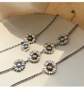 Macro shot of s925 vintage daisy bracelets and necklace with golden floral details