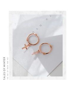 Detail of rose gold cross pendant hoop earrings made of sterling silver for women