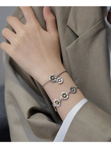 Detail of s925 silver daisy bracelets with retro finish on a model's wrist