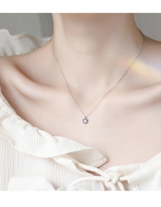 Detail view of S925 silver evil eye necklace worn on neck with blue stones
