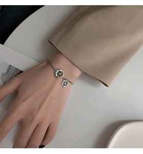 Detail shot of S925 sterling silver daisy bracelet with vintage finish on a model's wrist