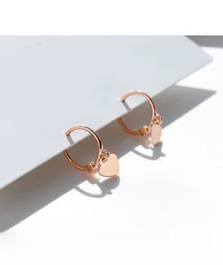Detail of rose gold 925 silver heart charm hoop earring on white elegant display