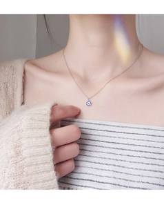 Detail view of s925 silver evil eye necklace with blue stone and white crystals on neck