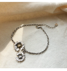 Detail of vintage S925 silver daisy bracelet with heart pendant and lobster clasp closure