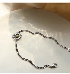 Detail of vintage s925 silver daisy bracelet with golden core and lobster clasp
