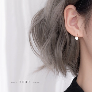 Elegant 925 sterling silver heart-shaped drop earrings worn by a model in soft light