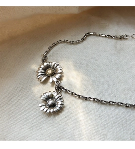 Close-up of vintage S925 sterling silver daisy bracelet on a beige linen background