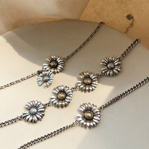 Retro s925 silver daisy bracelets with vintage finish on a textured stone surface