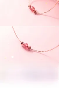 Gros plan détaillé d'un pendentif en forme de bonbon doré rose avec cristal de fraise