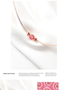 Détail macro d'un pendentif bonbon en cristal fraise sur un tissu en soie blanche