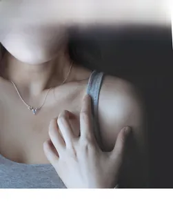 Detail of s925 silver elk necklace with moonstone pendant on female model neck