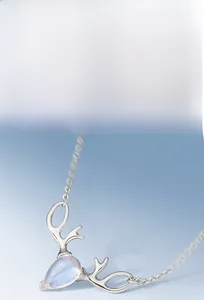 Macro shot of silver deer antler pendant necklace with a blue teardrop moonstone detail