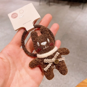 Détail d'un chouchou ourson marron tricoté avec charme love et petit nœud