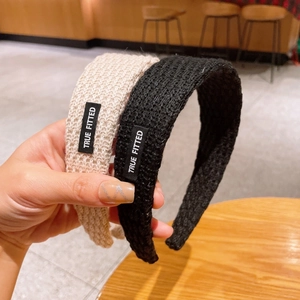 Knitted wide-brimmed headband with retro texture and True Fitted label in black and beige