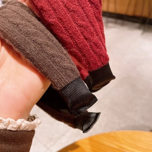 Detail of red and brown knitted wide headbands with textured ribbed fabric and soft black tips