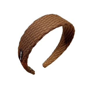Vintage style brown knitted wide headband for women featuring a textured cable knit pattern