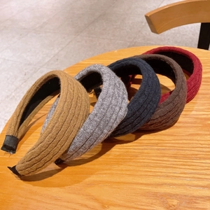 Macro view of five colors of braided knit headbands on a wooden table for daily wear