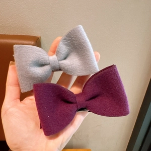 Close-up of wool felt bow hair clips in grey and purple with sturdy duckbill clips