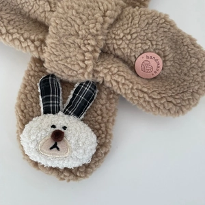 Vue détaillée du tissu en laine d'agneau et de l'écusson lapin sur l'écharpe enfant