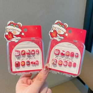 Detalle de uñas postizas rojas de Año Nuevo con diseños de Hello Kitty y danza del león